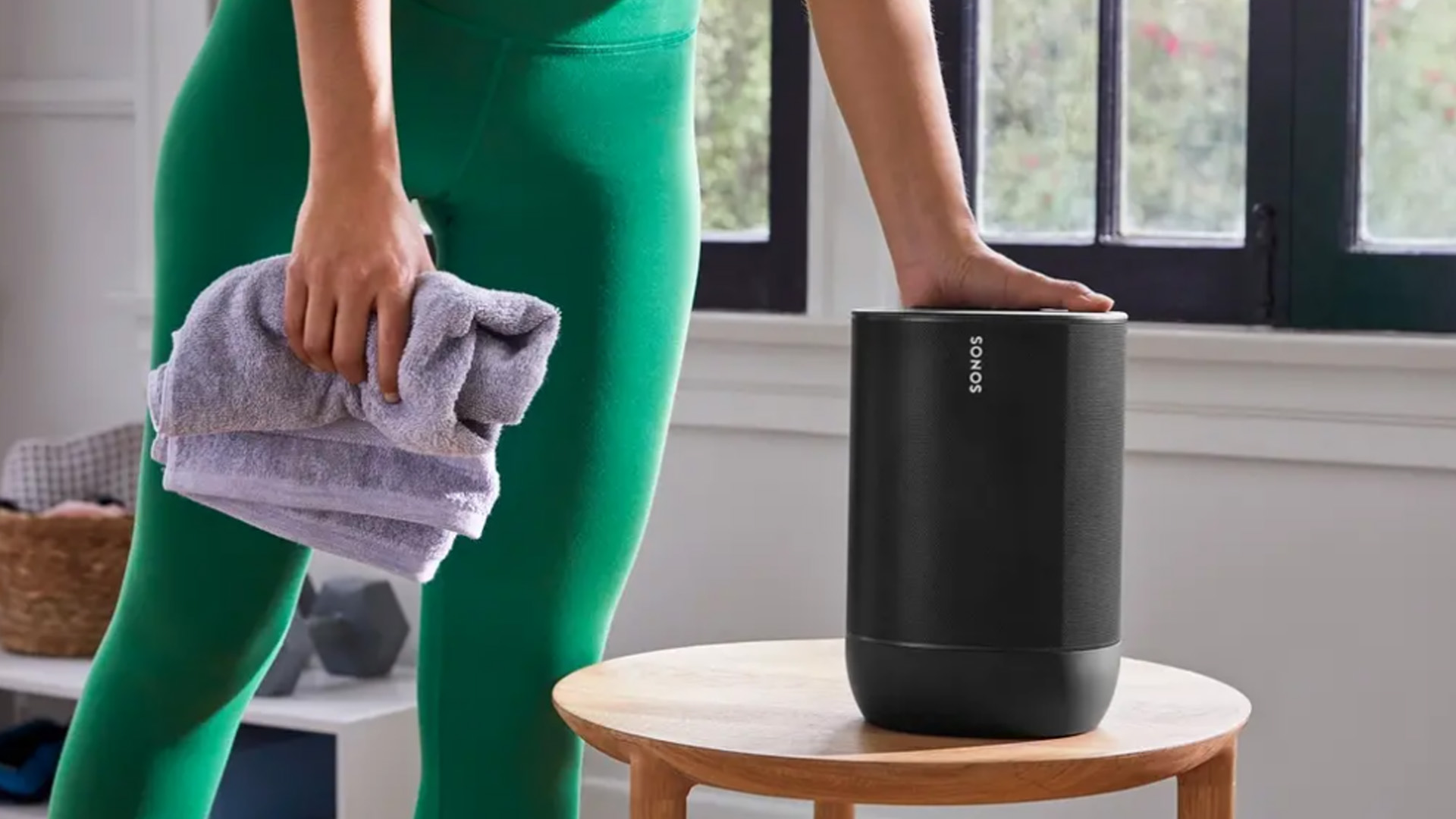 a woman pressing the top of the sonos move